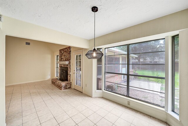 3507 Dawnwood Dr, Spring, TX 77380 - unfurnished dining area with a textured ceiling, a brick fireplace, and light tile patterned floors
