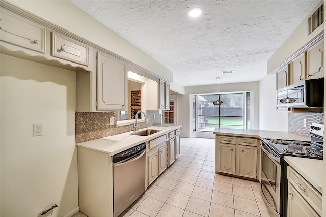 3507 Dawnwood Dr, Spring, TX 77380 - kitchen with appliances with stainless steel finishes, light countertops, decorative backsplash, light tile patterned floors, and a peninsula