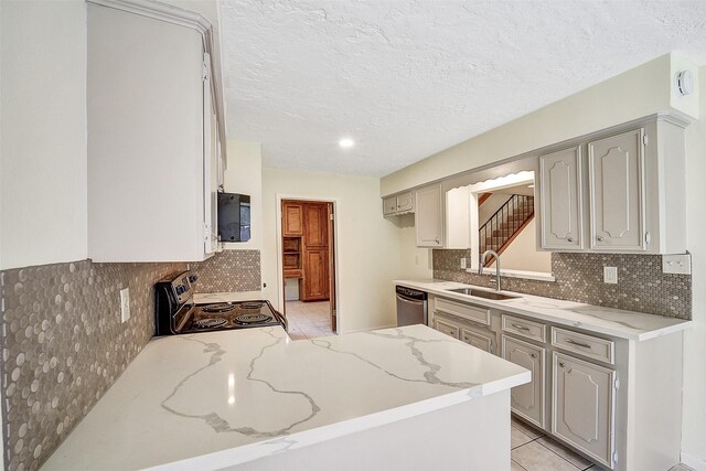 3507 Dawnwood Dr, Spring, TX 77380 - kitchen with appliances with stainless steel finishes, decorative backsplash, light tile patterned floors, a peninsula, and a textured ceiling