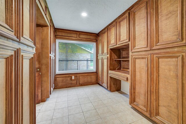 3507 Dawnwood Dr, Spring, TX 77380 - interior space with light tile patterned floors, a textured ceiling, built in study area, recessed lighting, and wooden walls