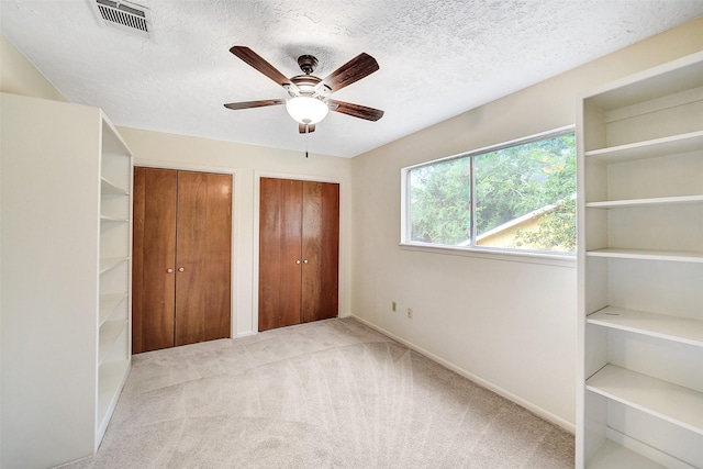 3507 Dawnwood Dr, Spring, TX 77380 - unfurnished bedroom featuring two closets, carpet flooring, a textured ceiling, and a ceiling fan