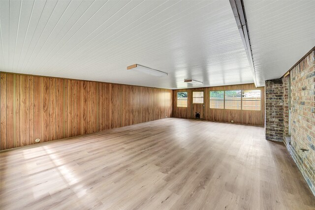 3507 Dawnwood Dr, Spring, TX 77380 - unfurnished living room featuring wood finished floors, wood walls, and brick wall