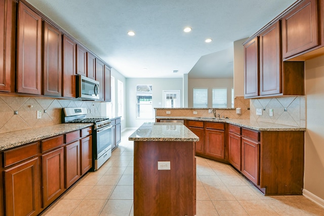 14307 Baron Creek Ln, Houston, TX 77044 - kitchen with stainless steel appliances, recessed lighting, a kitchen island, light stone countertops, and backsplash