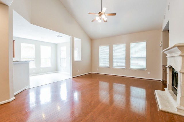 14307 Baron Creek Ln, Houston, TX 77044 - unfurnished living room featuring a glass covered fireplace, a ceiling fan, wood finished floors, and high vaulted ceiling