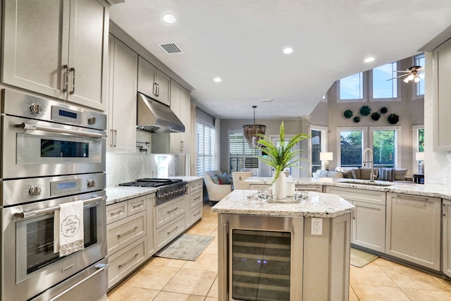 4502 Buffalo Lake Ct, Richmond, TX 77406 - kitchen with appliances with stainless steel finishes, beverage cooler, under cabinet range hood, light tile patterned flooring, and a peninsula