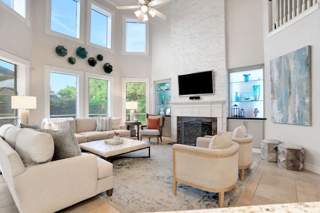 4502 Buffalo Lake Ct, Richmond, TX 77406 - tiled living room featuring a high ceiling, ceiling fan, a stone fireplace, and healthy amount of natural light