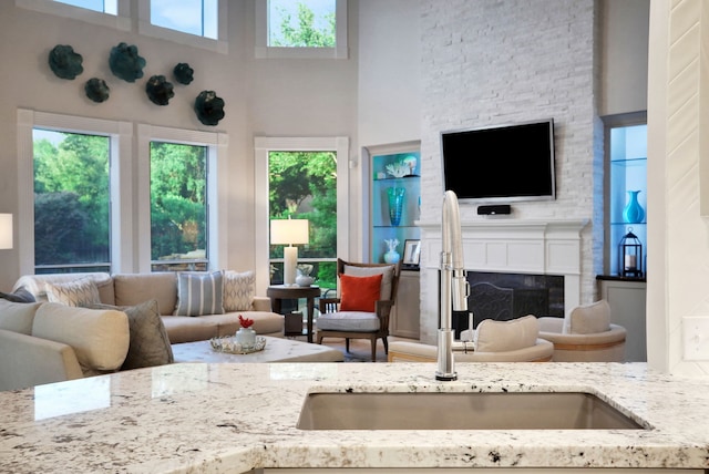 4502 Buffalo Lake Ct, Richmond, TX 77406 - living area featuring healthy amount of natural light, a towering ceiling, and a large fireplace