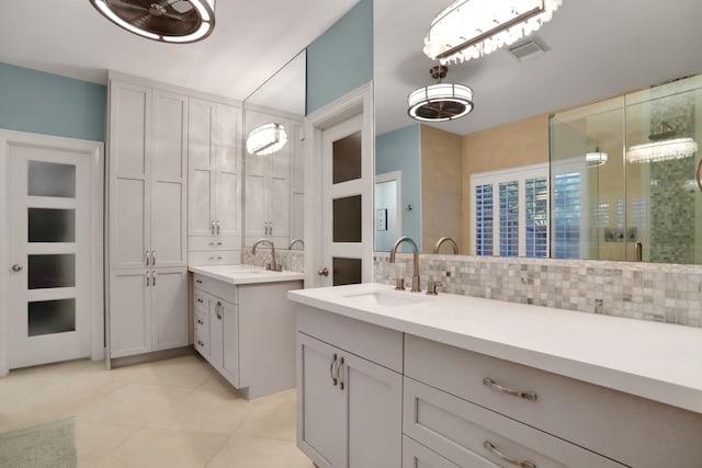 4502 Buffalo Lake Ct, Richmond, TX 77406 - bathroom with decorative backsplash, two vanities, tile patterned flooring, and a shower with shower door
