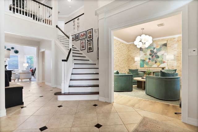 4502 Buffalo Lake Ct, Richmond, TX 77406 - stairway with a chandelier, crown molding, tile patterned floors, and a towering ceiling