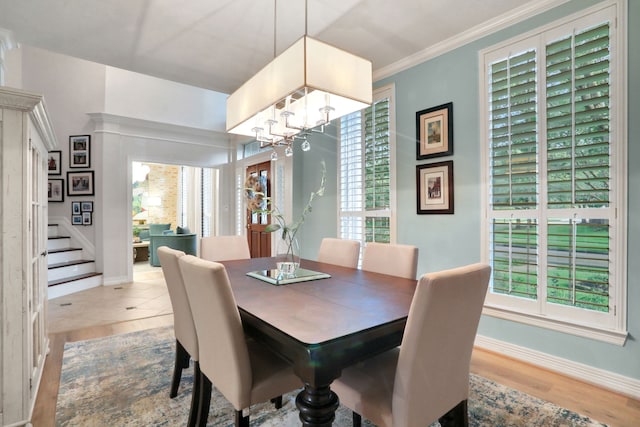 4502 Buffalo Lake Ct, Richmond, TX 77406 - dining area featuring stairs, plenty of natural light, a chandelier, ornamental molding, and wood finished floors