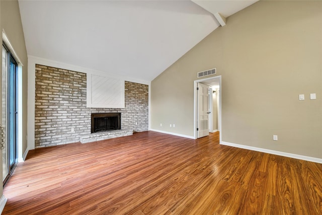 6401 Deihl Rd Unit 901, Houston, TX 77092 - unfurnished living room featuring a brick fireplace, wood finished floors, and high vaulted ceiling