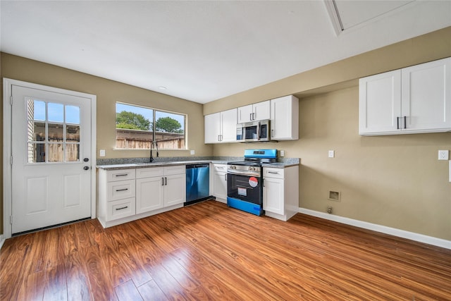 6401 Deihl Rd Unit 901, Houston, TX 77092 - kitchen featuring stainless steel appliances, white cabinetry, and light wood-style flooring
