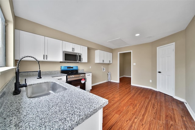 6401 Deihl Rd Unit 901, Houston, TX 77092 - kitchen featuring stainless steel appliances, white cabinetry, light stone counters, wood finished floors, and recessed lighting