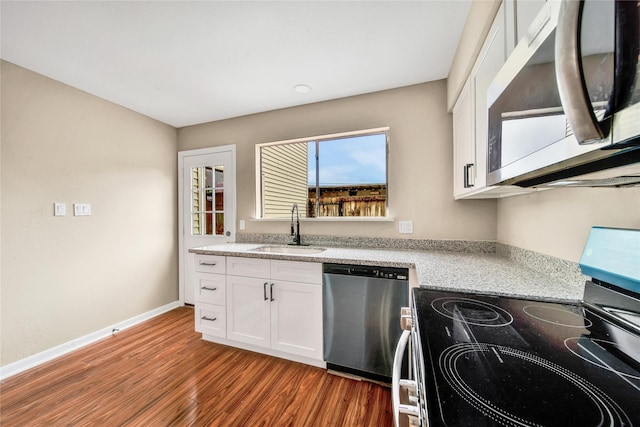 6401 Deihl Rd Unit 901, Houston, TX 77092 - kitchen with appliances with stainless steel finishes, wood finished floors, white cabinets, and light stone counters