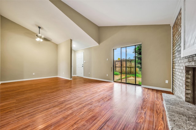 6401 Deihl Rd Unit 901, Houston, TX 77092 - unfurnished living room featuring ceiling fan, a brick fireplace, wood finished floors, and high vaulted ceiling