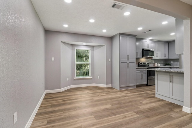 16820 Laurelwood Dr, Channelview, TX 77530 - kitchen with appliances with stainless steel finishes, gray cabinets, decorative backsplash, light wood-style floors, and recessed lighting