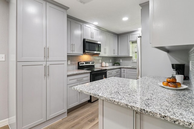 16820 Laurelwood Dr, Channelview, TX 77530 - kitchen featuring stainless steel microwave, black / electric stove, gray cabinets, and recessed lighting