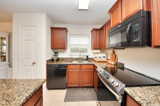 38327 Miranda Ln, Magnolia, TX 77355 - kitchen featuring black appliances, stone countertops, brown cabinets, and light tile patterned flooring