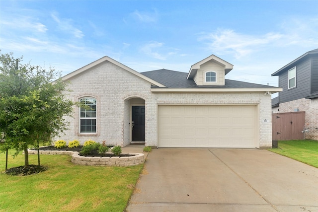 214 Water Grass Trl, Clute, TX 77531 - view of front of property featuring brick siding, driveway, an attached garage, and a front lawn