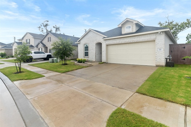 214 Water Grass Trl, Clute, TX 77531 - view of front of house featuring brick siding, a front yard, driveway, and a garage