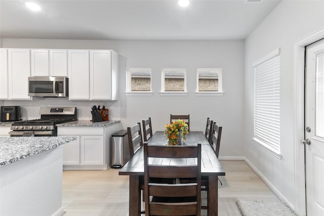 214 Water Grass Trl, Clute, TX 77531 - kitchen featuring stainless steel appliances, decorative backsplash, plenty of natural light, white cabinetry, and recessed lighting