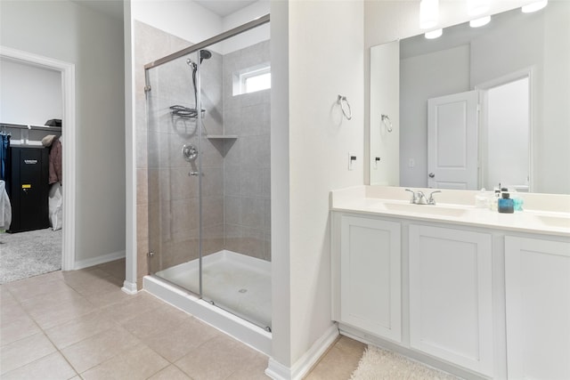 214 Water Grass Trl, Clute, TX 77531 - bathroom featuring a stall shower, tile patterned flooring, a walk in closet, and double vanity