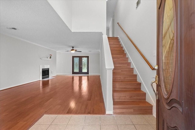 1726 Kemah Oaks Dr, Kemah, TX 77565 - stairway with ceiling fan, a fireplace, tile patterned floors, and crown molding