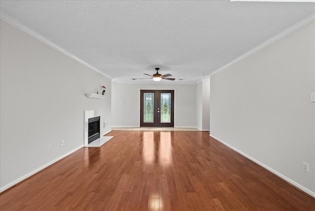 1726 Kemah Oaks Dr, Kemah, TX 77565 - unfurnished living room with ceiling fan, wood finished floors, a fireplace with flush hearth, ornamental molding, and a textured ceiling