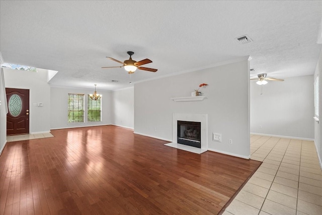 1726 Kemah Oaks Dr, Kemah, TX 77565 - unfurnished living room featuring a ceiling fan, a chandelier, a fireplace with flush hearth, hardwood / wood-style flooring, and ornamental molding