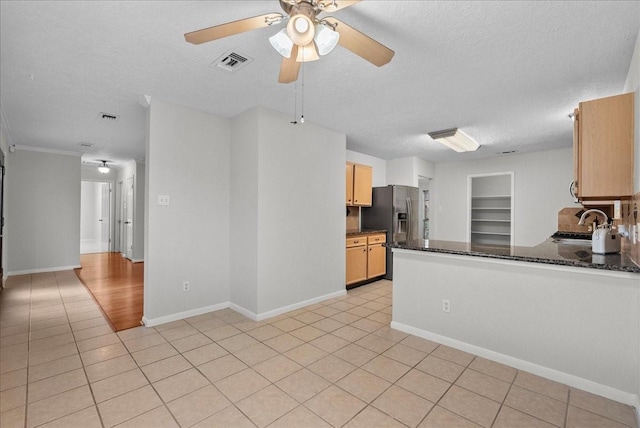 1726 Kemah Oaks Dr, Kemah, TX 77565 - kitchen with stainless steel fridge with ice dispenser, a textured ceiling, a ceiling fan, light tile patterned floors, and a peninsula