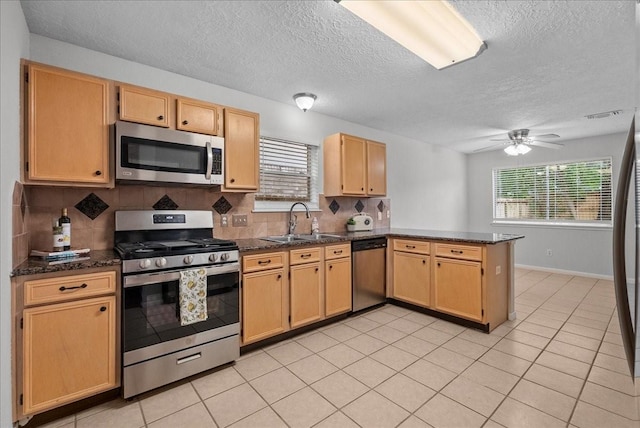 1726 Kemah Oaks Dr, Kemah, TX 77565 - kitchen with appliances with stainless steel finishes, a peninsula, decorative backsplash, plenty of natural light, and a textured ceiling