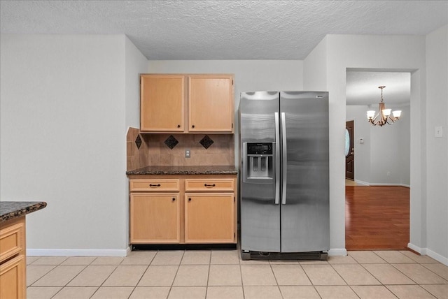 1726 Kemah Oaks Dr, Kemah, TX 77565 - kitchen with stainless steel refrigerator with ice dispenser, backsplash, a chandelier, dark stone countertops, and a textured ceiling