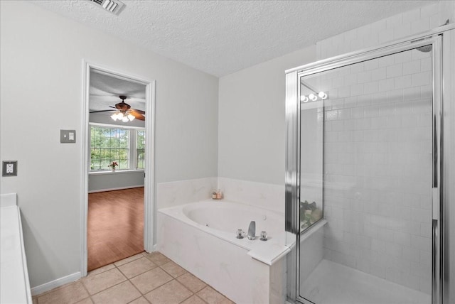 1726 Kemah Oaks Dr, Kemah, TX 77565 - bathroom with a shower stall, tile patterned floors, a bath, a textured ceiling, and a ceiling fan