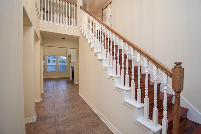 28015 Silverstream Ct, Fulshear, TX 77441 - staircase with a high ceiling and a fireplace