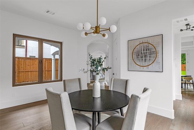 2031 Peppermill Rd, Houston, TX 77080 - dining space with light wood-style flooring, a chandelier, and arched walkways
