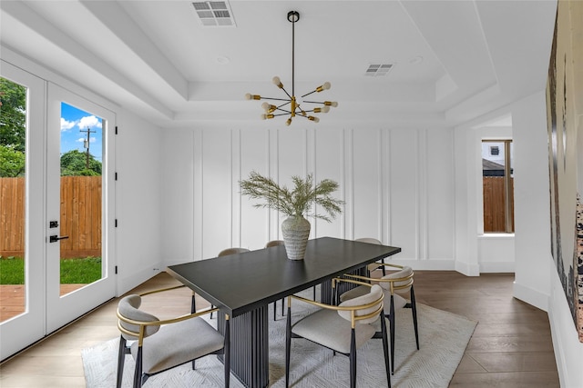 2031 Peppermill Rd, Houston, TX 77080 - dining space with a tray ceiling, a chandelier, a decorative wall, and wood finished floors