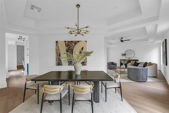 2031 Peppermill Rd, Houston, TX 77080 - dining space featuring a raised ceiling, light wood-style flooring, a chandelier, and ceiling fan