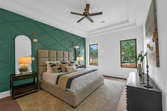 2031 Peppermill Rd, Houston, TX 77080 - bedroom with wood finished floors, a tray ceiling, and a ceiling fan