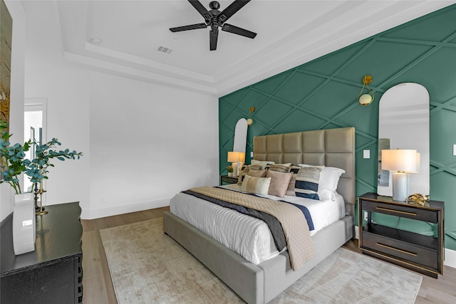2031 Peppermill Rd, Houston, TX 77080 - bedroom with an accent wall, wood finished floors, a ceiling fan, and a tray ceiling
