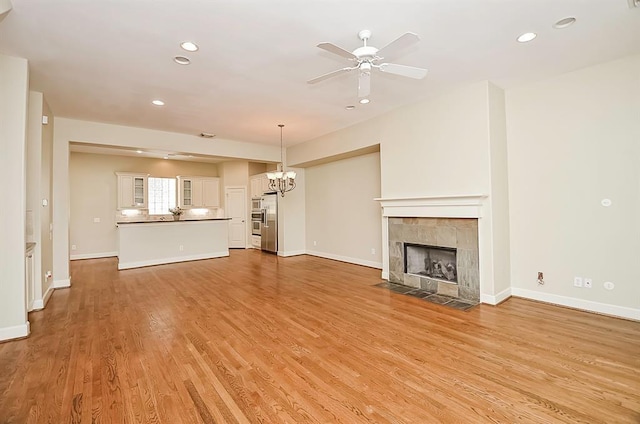 222 Knox St Unit F, Houston, TX 77007 - unfurnished living room featuring a chandelier, recessed lighting, a fireplace, a ceiling fan, and light wood-type flooring