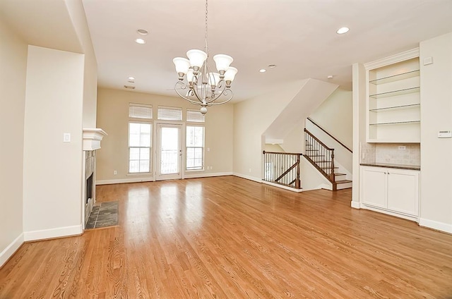 222 Knox St Unit F, Houston, TX 77007 - unfurnished living room featuring a chandelier, light wood-style flooring, stairs, recessed lighting, and a fireplace