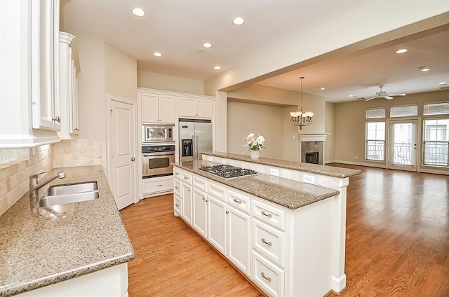 222 Knox St Unit F, Houston, TX 77007 - kitchen with built in appliances, a fireplace, a kitchen island, ceiling fan, and tasteful backsplash