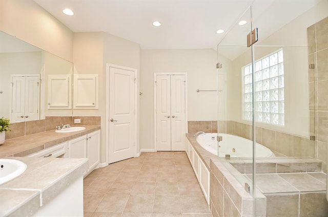 222 Knox St Unit F, Houston, TX 77007 - bathroom featuring vanity, a tub with jets, recessed lighting, and tile patterned floors