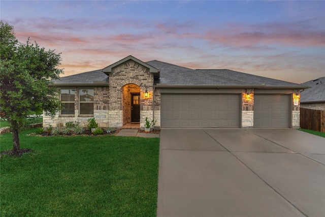 11503 Parrot Fish Ct, Conroe, TX 77304 - view of front of property featuring a garage, concrete driveway, a lawn, stone siding, and a shingled roof