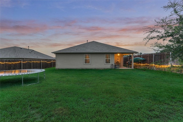 11503 Parrot Fish Ct, Conroe, TX 77304 - rear view of property featuring a trampoline, a fenced backyard, roof with shingles, and a patio