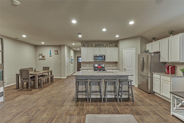 11503 Parrot Fish Ct, Conroe, TX 77304 - kitchen with appliances with stainless steel finishes, dark wood finished floors, white cabinetry, recessed lighting, and a center island with sink