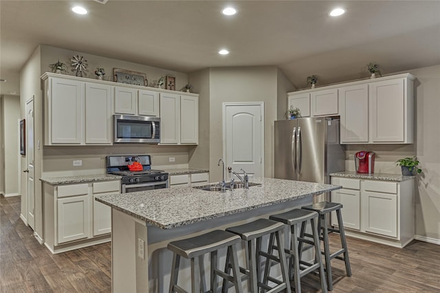 11503 Parrot Fish Ct, Conroe, TX 77304 - kitchen featuring stainless steel appliances, white cabinets, dark wood-type flooring, recessed lighting, and a kitchen island with sink