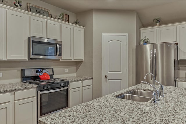 11503 Parrot Fish Ct, Conroe, TX 77304 - kitchen with appliances with stainless steel finishes, light stone counters, and white cabinetry
