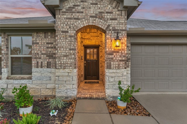11503 Parrot Fish Ct, Conroe, TX 77304 - exterior entry at dusk with stone siding and a garage