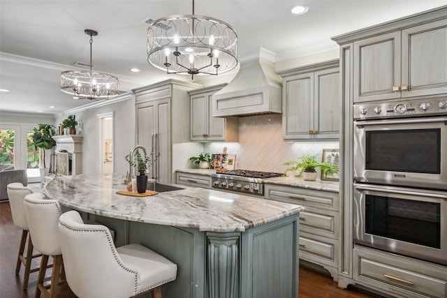 1114 W Cottage St, Houston, TX 77009 - kitchen featuring appliances with stainless steel finishes, premium range hood, ornamental molding, recessed lighting, and a chandelier
